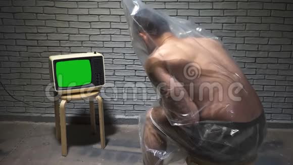 包装中男人看复古电视的视频视频的预览图