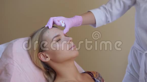 医生或美容师用套管针为中年妇女做皮肤刺生物重组和视频的预览图
