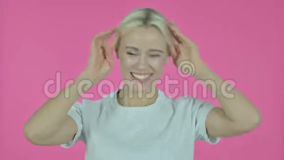 粉红背景下快乐的年轻女子跳舞视频的预览图