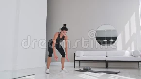 健身妇女在家做汉堡锻炼中弹年轻女子做俯卧撑和慢速跳跃运动视频的预览图