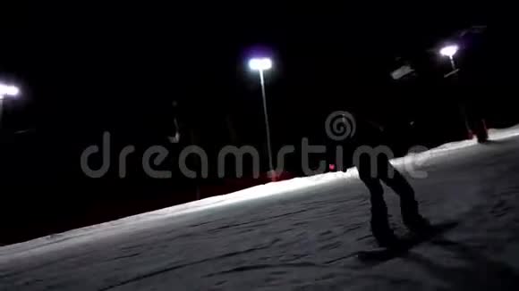 年轻的女滑雪运动员自信地沿着赛道灯光赛车晚上在滑雪场骑马视频的预览图