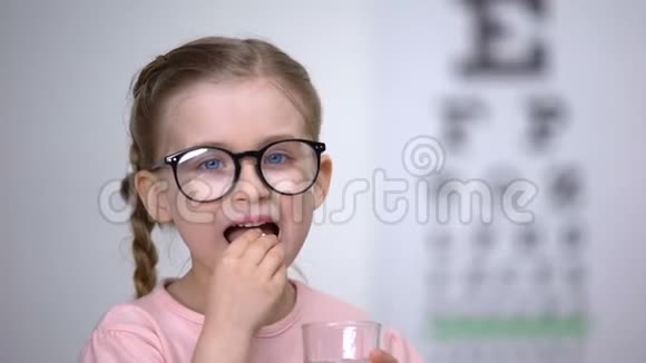 戴眼镜的漂亮小女孩用避孕药治疗视力视频的预览图