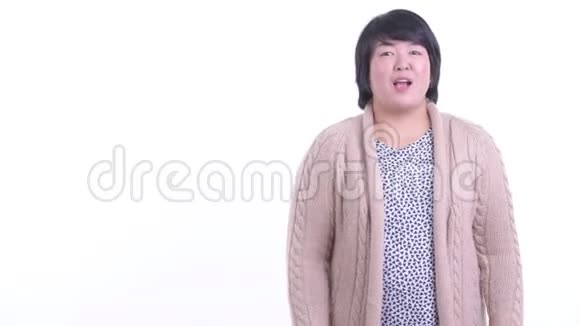 快乐超重的亚洲女人一边说话一边展示冬天的东西视频的预览图