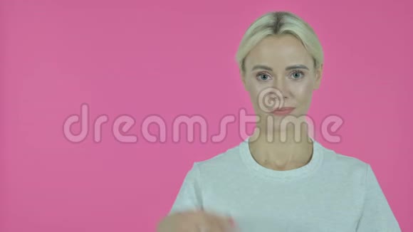 年轻女性用手展示产品粉红背景视频的预览图