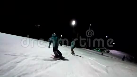 朋友们一起享受冬季运动两个朋友在夜空下同步乘坐滑雪板冬季视频的预览图