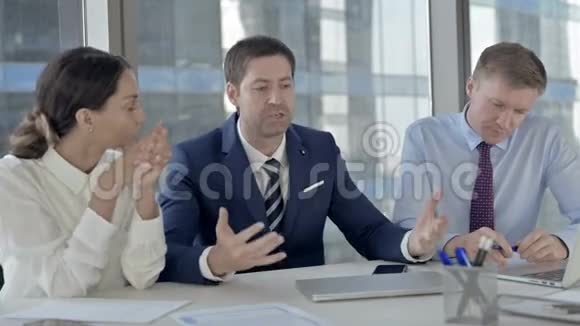 令人不安的中年商人与他的助手在办公室桌上争吵视频的预览图