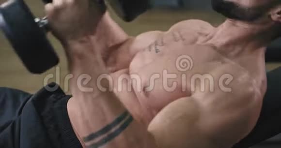 一个肌肉发达的家伙在锻炼他的腹肌和肌肉有一个特写镜头视频的预览图