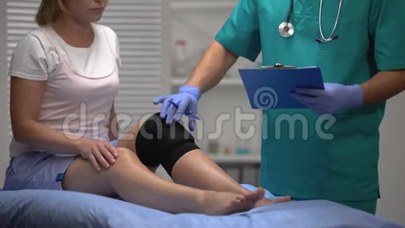 骨科医生检查女性患者腿的膝撑和填充文件视频的预览图