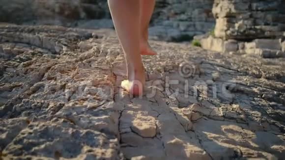 女人在夏天的岩石上行走双腿紧闭视频的预览图