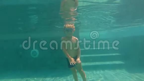 慢动作水下拍摄一个快乐的孩子在游泳池里玩健康生活方式视频的预览图