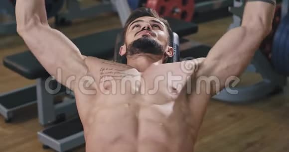 一个非常健康的年轻人正在健身房锻炼在他的三头肌里他是通过在健身房举重来锻炼的视频的预览图