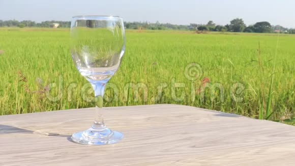 在节日的稻田背景下倒入酒杯的饮料视频的预览图