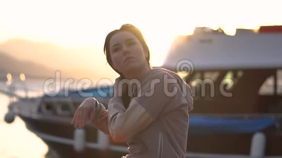 年轻漂亮的女孩摇着她的头发站在船旁动作缓慢视频的预览图