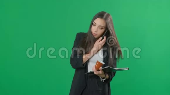 女商人一边处理文件一边喝咖啡一边打电话铬绿视频的预览图