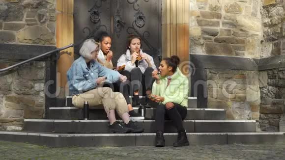 多种族的女性青少年在户外吃椒盐卷饼视频的预览图