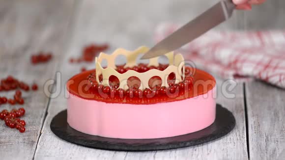 女人手切了一个自制的红醋栗慕斯蛋糕视频的预览图