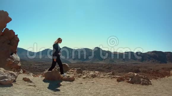 女摄影师走在山脊上视频的预览图