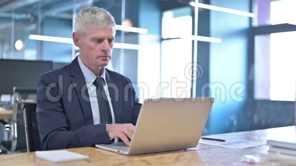 办公室桌上一位疲惫的中年商人颈部疼痛视频的预览图