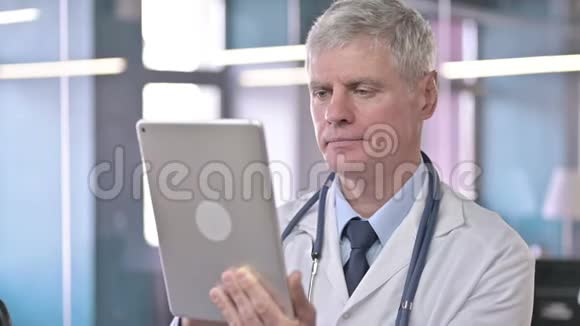 中年医生在平板上滚动的肖像视频的预览图