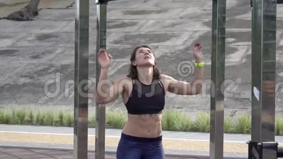 女子在障碍过程中在猴子酒吧锻炼女运动员穿越猴子酒吧女人在高处或者视频的预览图
