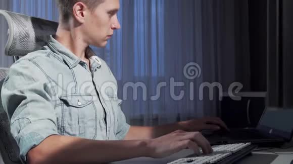 一名男性自由职业者利用两台电脑在深夜工作视频的预览图