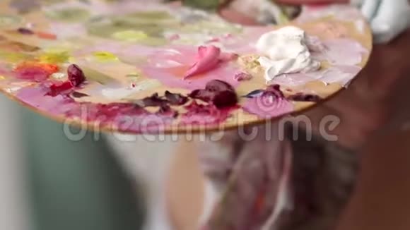 一个手里拿着油画颜料的女孩的特写慢动作视频的预览图