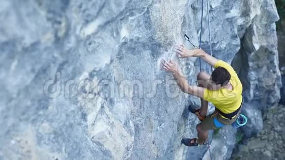 人攀岩者的俯视图攀登悬崖上的运动路线搜索到达和抓住持有户外岩石视频的预览图