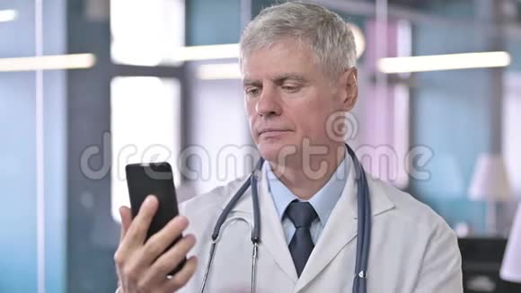 中年医生在手机上滚动的画像视频的预览图