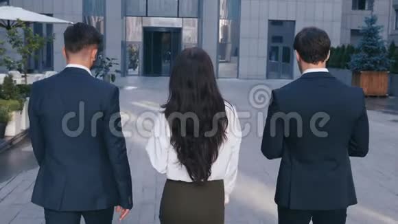 三个成功的商人两个英俊的男人和一个自信的女人在办公楼里散步视频的预览图