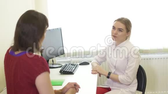 女人听医生的推荐医生和病人的谈话年轻的女医生在医院和病人谈话视频的预览图
