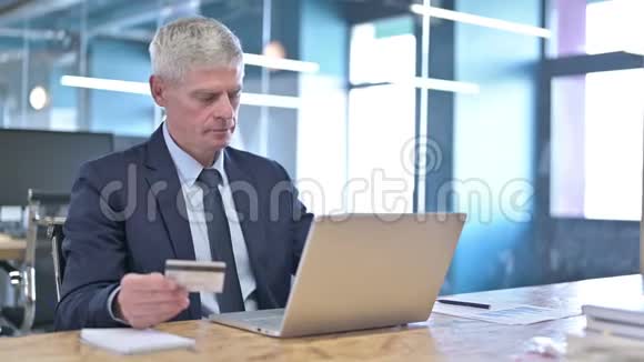 失望的中年商务人士使用电脑信用卡视频的预览图