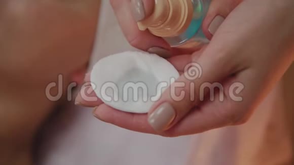 美容师在棉垫上涂上乳液视频的预览图
