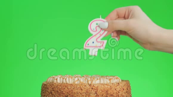 在一个美味的蛋糕上放两个生日蜡烛绿色屏幕2视频的预览图