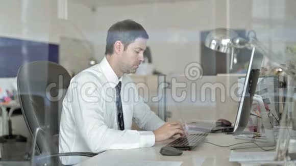 生病的中年商人在办公室电脑上工作咳嗽视频的预览图