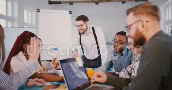 快乐男财务公司老板在现代办公室的团队会议上与同事一起制作挂图视频的预览图