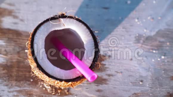 在海滩咖啡馆的桌子上一块块冰从上面掉进了一个椰子新鲜椰子里超级慢动作镜头视频的预览图