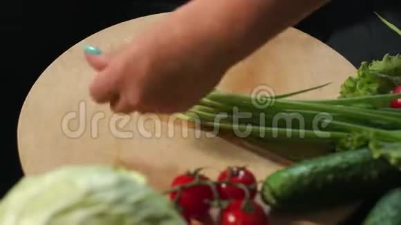 一个年轻女孩的特写镜头把新鲜的洋葱切在木板上视频的预览图
