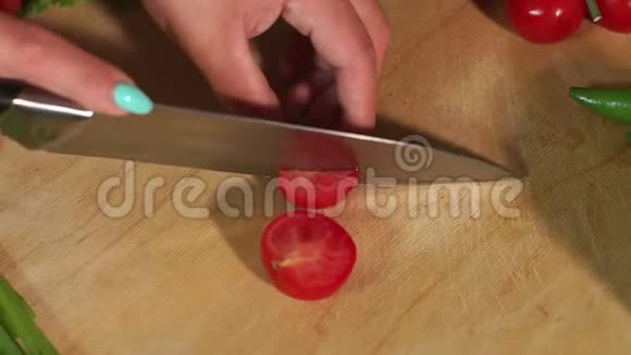 特写女孩在木制砧板上切樱桃西红柿慢动作视频的预览图