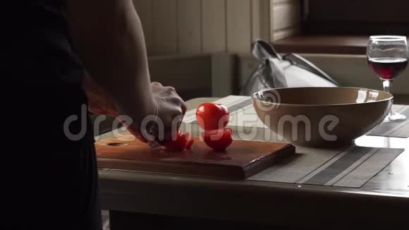女人把红的生的新鲜西红柿切成薄片做沙拉木工切割板准备浪漫的晚餐回家视频的预览图