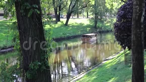 里加拉托维亚市中心公园在河边一艘古老的小木船在运河里游泳视频的预览图