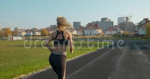 强壮的健身女孩在体育场跑步她正在庆祝她锻炼的结束视频的预览图