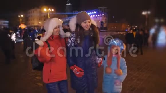 在城镇广场举行圣诞晚会快乐的一家人在城镇广场上快乐地跳跃视频的预览图