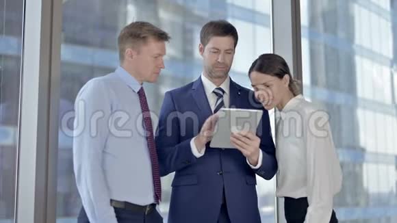 在会议室使用平板电脑和微笑的开朗的执行商务人员视频的预览图