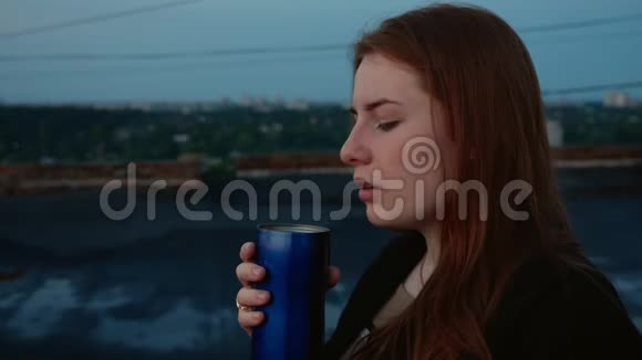 红发女孩喝着热杯茶视频的预览图