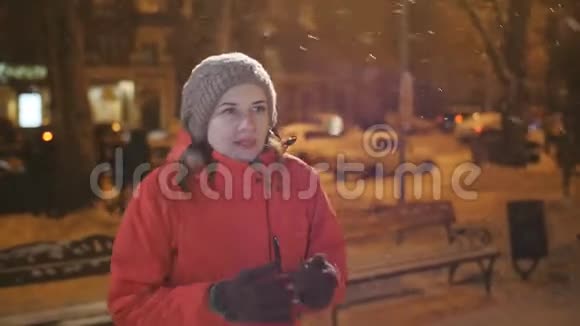 两个朋友在冬天的晚上在城里见面城里两个女孩在雪地里拥抱和欢乐的相遇视频的预览图