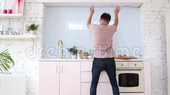 年轻开朗的男人在厨房做饭时跳舞视频的预览图