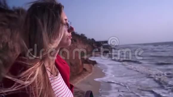 那个戴着紫色眼镜的女孩望着大海风吹乱了她的头发视频的预览图