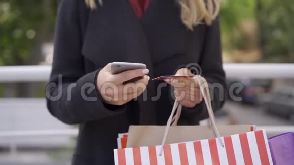 接近白种人的女人用她的手机和信用卡在线支付支付方便现代视频的预览图