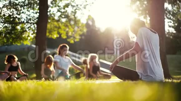 一群女人在夏天阳光明媚的早晨在公园里伸着脖子视频的预览图