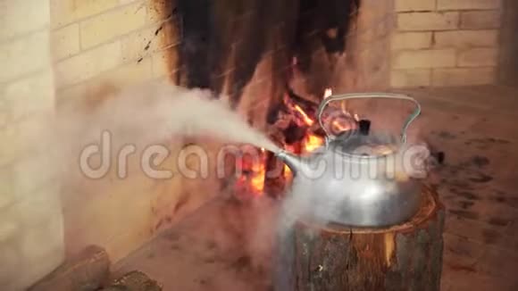 木制原木上的热水壶壁炉背景上的烧水壶圣诞老人手拿热水壶视频的预览图